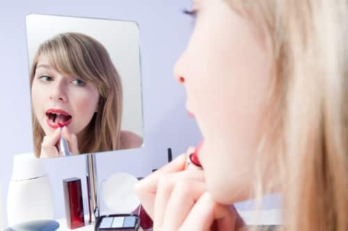 Image result for girl applying lipstick in mirror