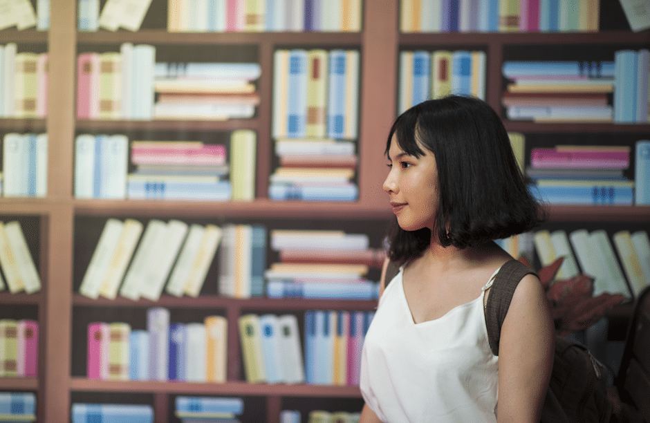 Woman Wearing V-neck Sleeveless Top Near Bookshelf